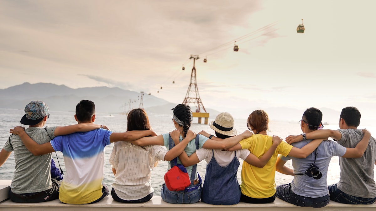 A celebratory group of colleagues arm-in-arm on a reward trip by the water